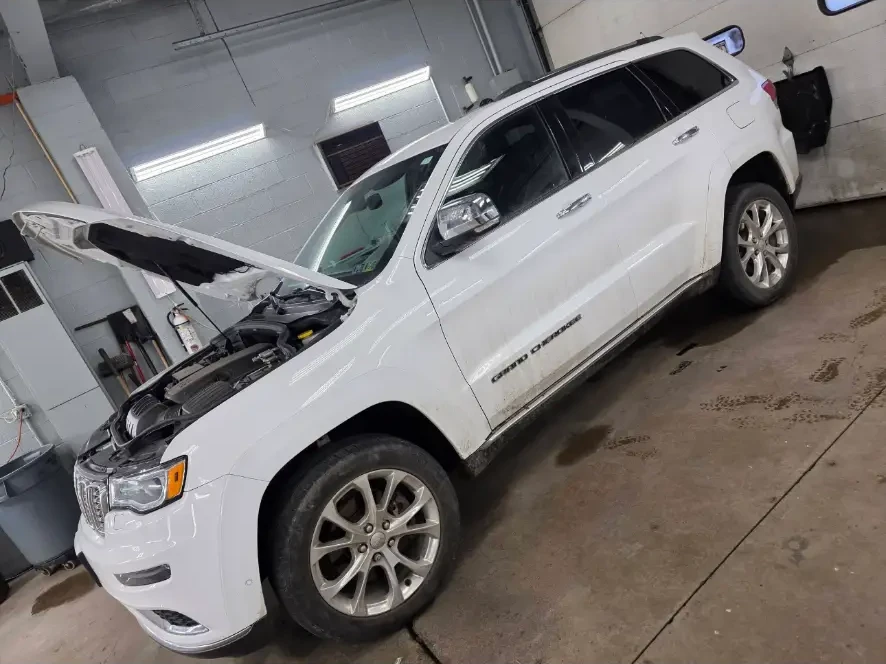 Before: white Jeep Grand Cherokee with road grime along the lower panels